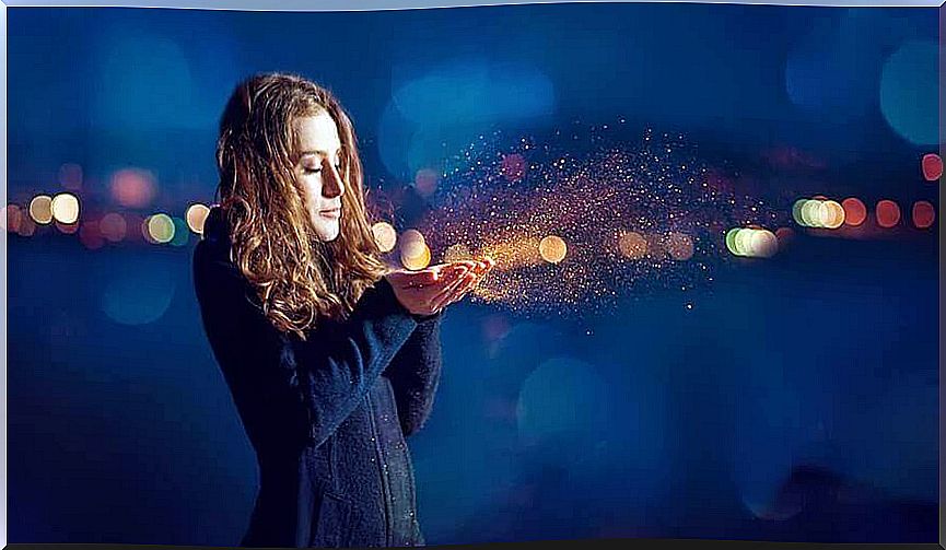 woman blowing gold dust