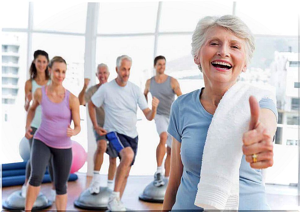 a woman over the age of 50 thumbs up during a gym class