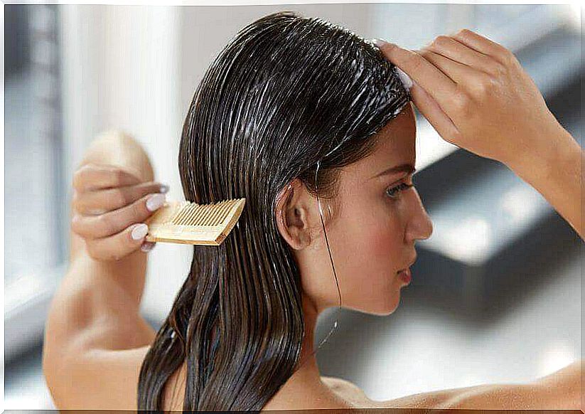 A woman combs her hair.