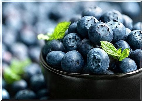 blueberries and leaves in a cup