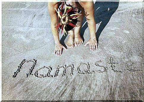 a woman wrote in the sand namaste